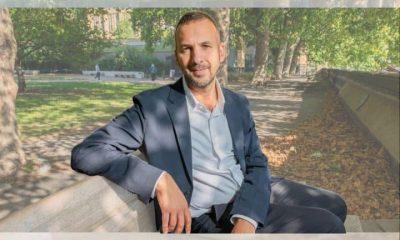 Zack Polanski of the Green Party sat on a bench outside in a relaxed manner posing for camera
