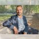 Zack Polanski of the Green Party sat on a bench outside in a relaxed manner posing for camera
