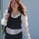 Ellie Kamio, one of the Filton 25, smiling while walking outside Woolwich Crown Court, London, in April 2026 with one hand on her shoulder keeping her backpack strap in place