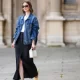 PARIS, FRANCE - MAY 25: Marissa Cox wears an Arket black skirt, an Arket white t-shirt, a blue oversize Agolde denim jacket, ATP Atelier pale pastel yellow flats / shoes, a white Arket leather bag, Jimmy Fairly x Reformation sunglasses, and Alighieri necklace, during a street style fashion photo session, on May 25, 2024 in Paris, France. (Photo by Edward Berthelot/Getty Images)