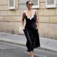 Gili Biegun wears a black silk midi dress with white lace detailing by Maria McManus, cream-white leather shoulder bag, red kitten-heel flip-flops, and diamond earrings during Day One of Paris Fashion Week - Haute Couture Fall/Winter 2026/2027 on July 06, 2026 in Paris, France.