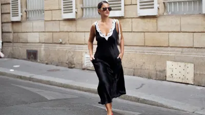 Gili Biegun wears a black silk midi dress with white lace detailing by Maria McManus, cream-white leather shoulder bag, red kitten-heel flip-flops, and diamond earrings during Day One of Paris Fashion Week - Haute Couture Fall/Winter 2026/2027 on July 06, 2026 in Paris, France.