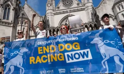 Protesters against greyhound racing hold a banner saying End Dog Racing Now