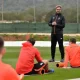 Jürgen Klopp stands to address his football players, who are sat with their backs to camera all wearing the same red jacket, during what he describes as a ‘pre-season training’ camp in La Manga in February 2017