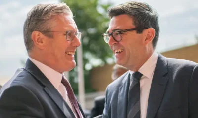 Keir Starmer and Andy Burnham greeting one another and smiling in close proximity