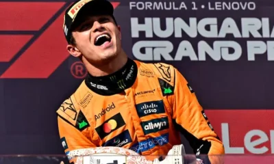 Lando Norris celebrates on the podium with a trophy after winning the Hungarian Grand Prix