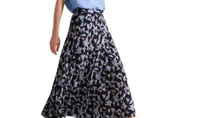 A woman wearing a light blue top (head cropped out), and a printed skirt in a mix of blues