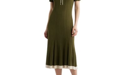 A woman wearing an olive green polo dress and brown heels