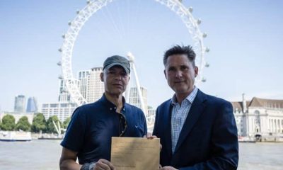 MPs Clive Lewis and Charlie Maynard in front of the Thames and London Eye, holding an open letter concerning Thames Water