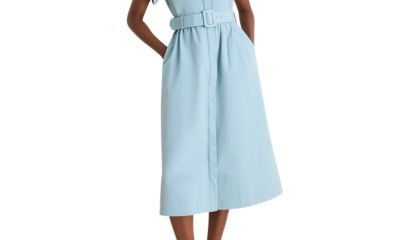 A woman wearing a light blue shirtdress with yellow kitten heels