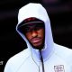 Marcus Rashford wearing a white England zip-up top, hood pulled up over his head
