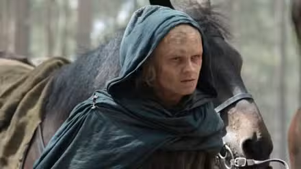 Aegon Targaryen scarred and burned, leading a horse.