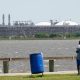 A man stares across the bay from the vast Sabine Pass LNG export terminal, the world's largest