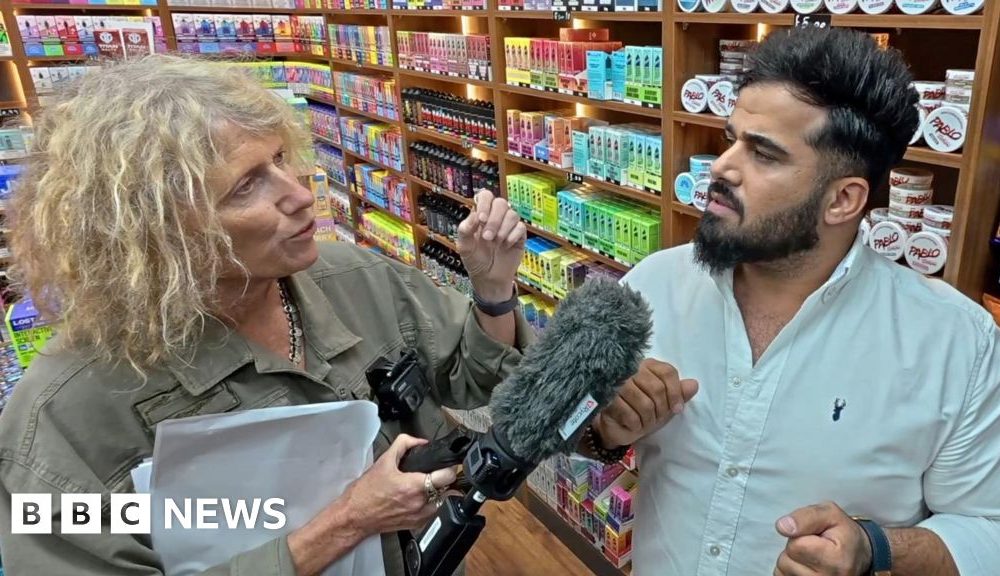 Sue Mitchell (L) holds microphone to Twana Jamal (R)