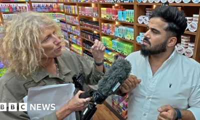 Sue Mitchell (L) holds microphone to Twana Jamal (R)