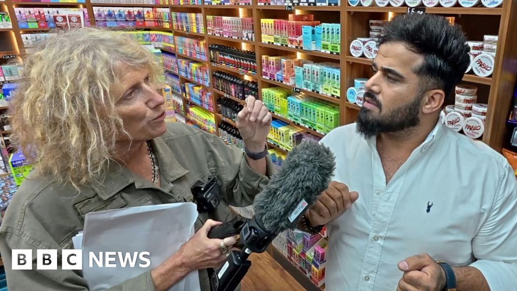 Sue Mitchell (L) holds microphone to Twana Jamal (R)