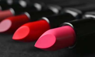 tubes of lipstick laying on a dark surface
