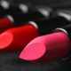 tubes of lipstick laying on a dark surface