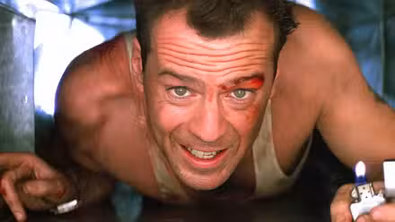 Bruce Willis, playing John McClane, crawls through a duct with a lighter in Die Hard.