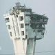 A large control tower is shown with windows blown out and the exterior crumbling