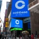Coinbase advertising sign in Times Square, New York with pedestrians.