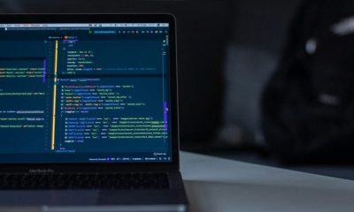 A laptop computer on a desk with code on the screen to visualise the hacker story