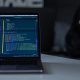 A laptop computer on a desk with code on the screen to visualise the hacker story