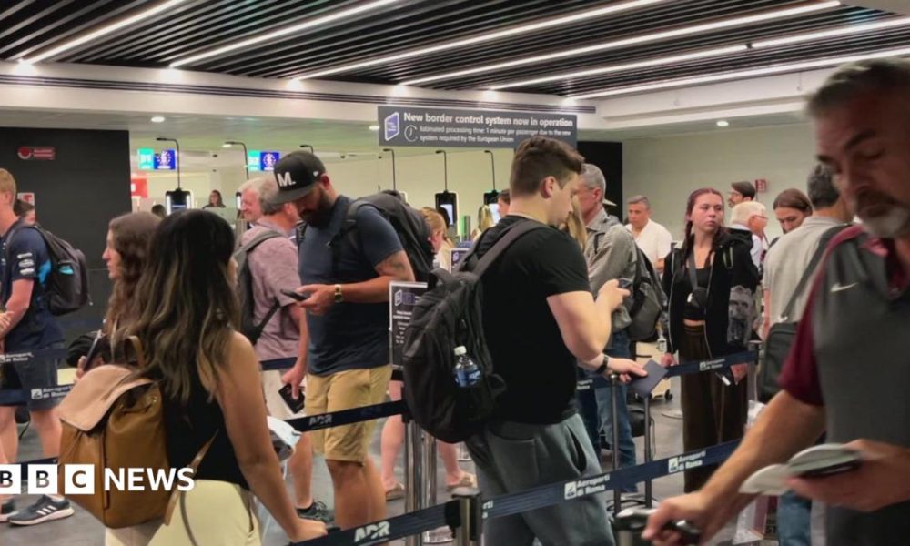 People move through the queue for the Entry Exit System process at Fuimicino Airport in Rome, Italy.