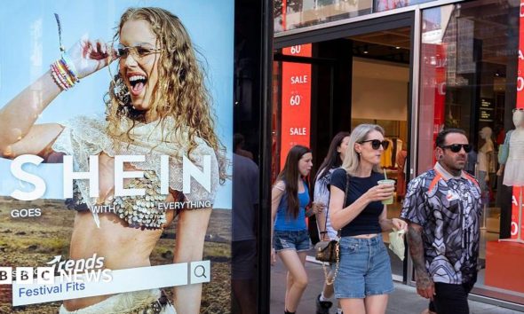 Peolep walking past a bus stop advertising for Chinese e-commerce fashion company Shein on 11 July 2026 in London.