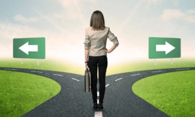 businesswoman stands at a crossroads and must make a decision