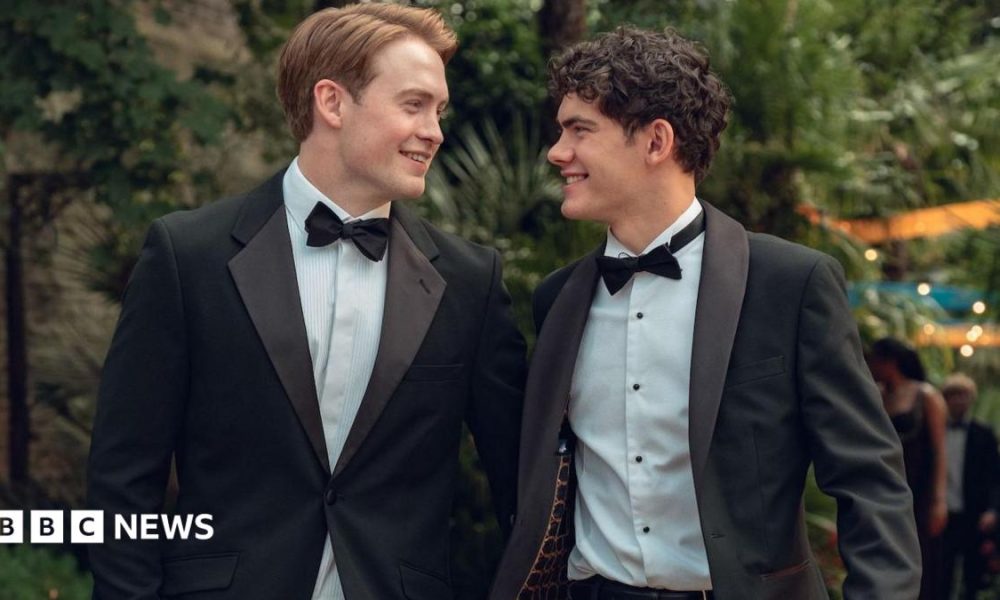 Production still from Heartstopper Forever showing Kit Connor and Joe Locke smiling at each other in tuxedos