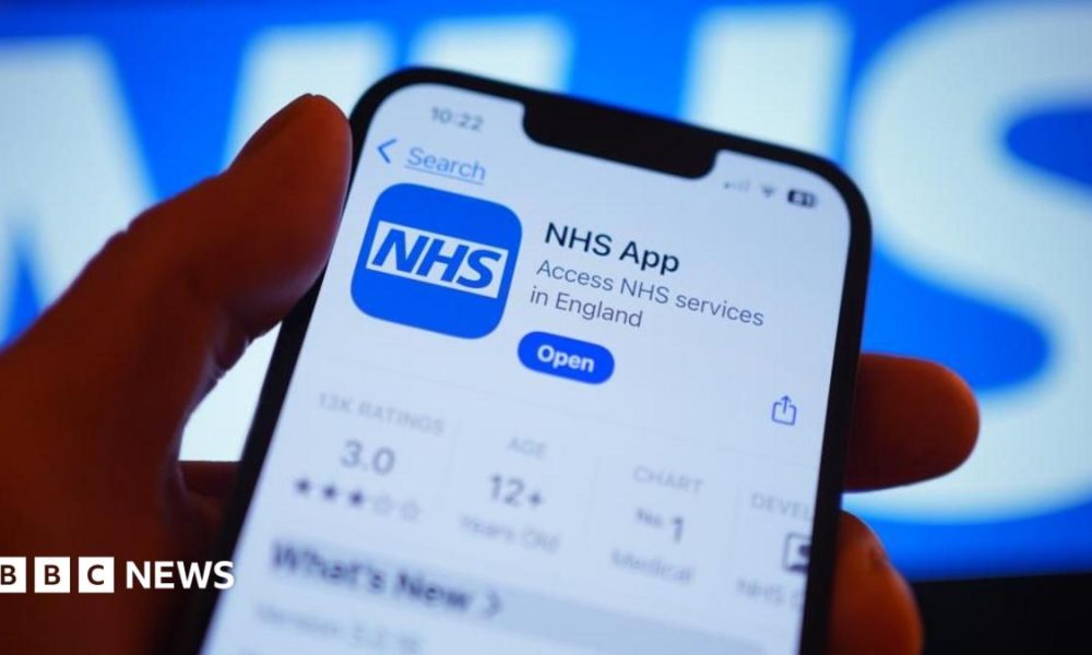 A hand holds a smartphone displaying the NHS app after it has been downloaded.