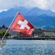 A view of a Swiss flag on a boat on lake Lucerne and Lucerne city in central Switzerland
