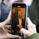 Two hands holding a phone with Zack Polanski on the screen