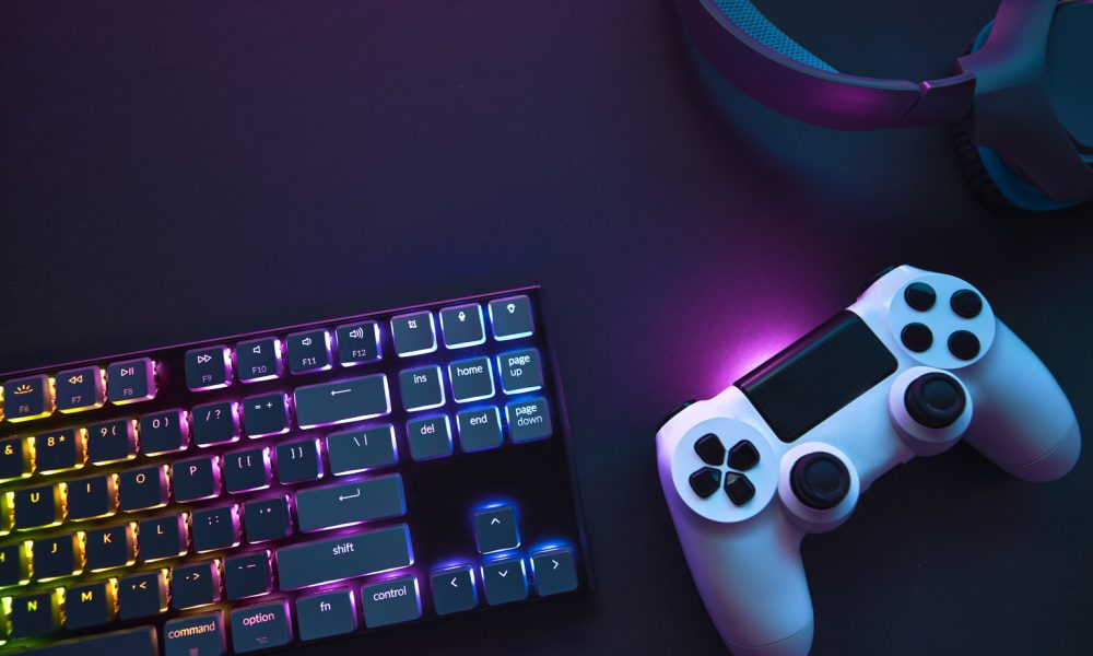 Top down view of colorful illuminated gaming accessories laying on table.