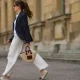 Cleo zu Oettingen-Spielberg wearing navy blue striped Polo Ralph Lauren jacket, white polo and white linen pants and beige Loewe bag via Lodenfrey SS21 on May 10, 2021 in Munich, Germany.