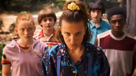 Eleven and the rest of the cast stand and look determined towards the camera in Stranger Things.