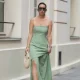 PARIS, FRANCE - MAY 08: Maria Rosaria Rizzo wears dark brown hair in a ponytail, sunglasses by Bottega Veneta, a fitted sage green strapless dress with a structured bodice and a sheer flowing maxi skirt from La Petite Etoile, gold-tone earrings, a silver-tone watch, a cream top-handle bag Moon Songmont, green strappy sandals heels shoes by Bottega Veneta, during a street style fashion photo session, on May 08, 2026 in Paris, France. (Photo by Edward Berthelot/Getty Images)