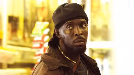 Michael K Williams looking to the side with a serious expression in The Wire.