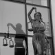 A statue of Lady Justice holding scales in front of a window.