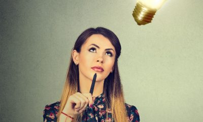 woman looks up thoughtfully at an imaginary lightbulb