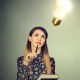 woman looks up thoughtfully at an imaginary lightbulb