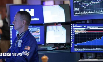 A stock market trader monitors screens on the stock market