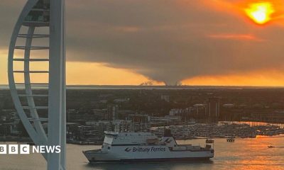 New Forest fire seen from Portsmouth with the Spinnaker Tower and ferry in the foreground.