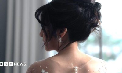 A bride with her in an updo looks over her shoulder.