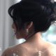 A bride with her in an updo looks over her shoulder.