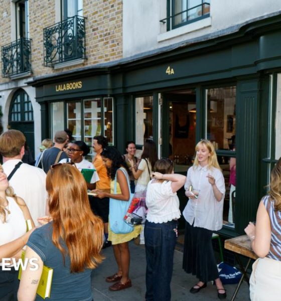 People standing outside a shop with green awning and the lettering 'Lala Books'