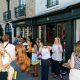 People standing outside a shop with green awning and the lettering 'Lala Books'