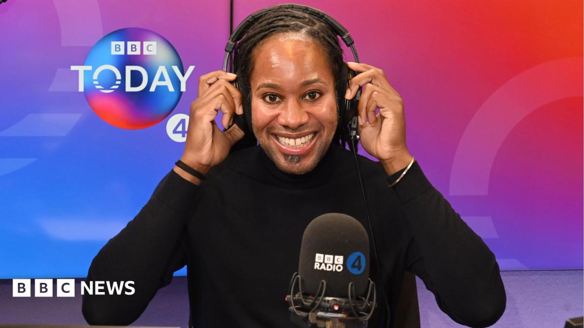 Holding headphones on his head, BBC Radio 4 Today Christmas guest editor Prof Jason Arday smiles at the camera in the studio.