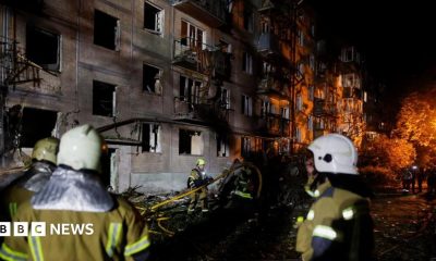 Firefighters work at the site of an apartment building hit by a Russian missile strike in Kyiv